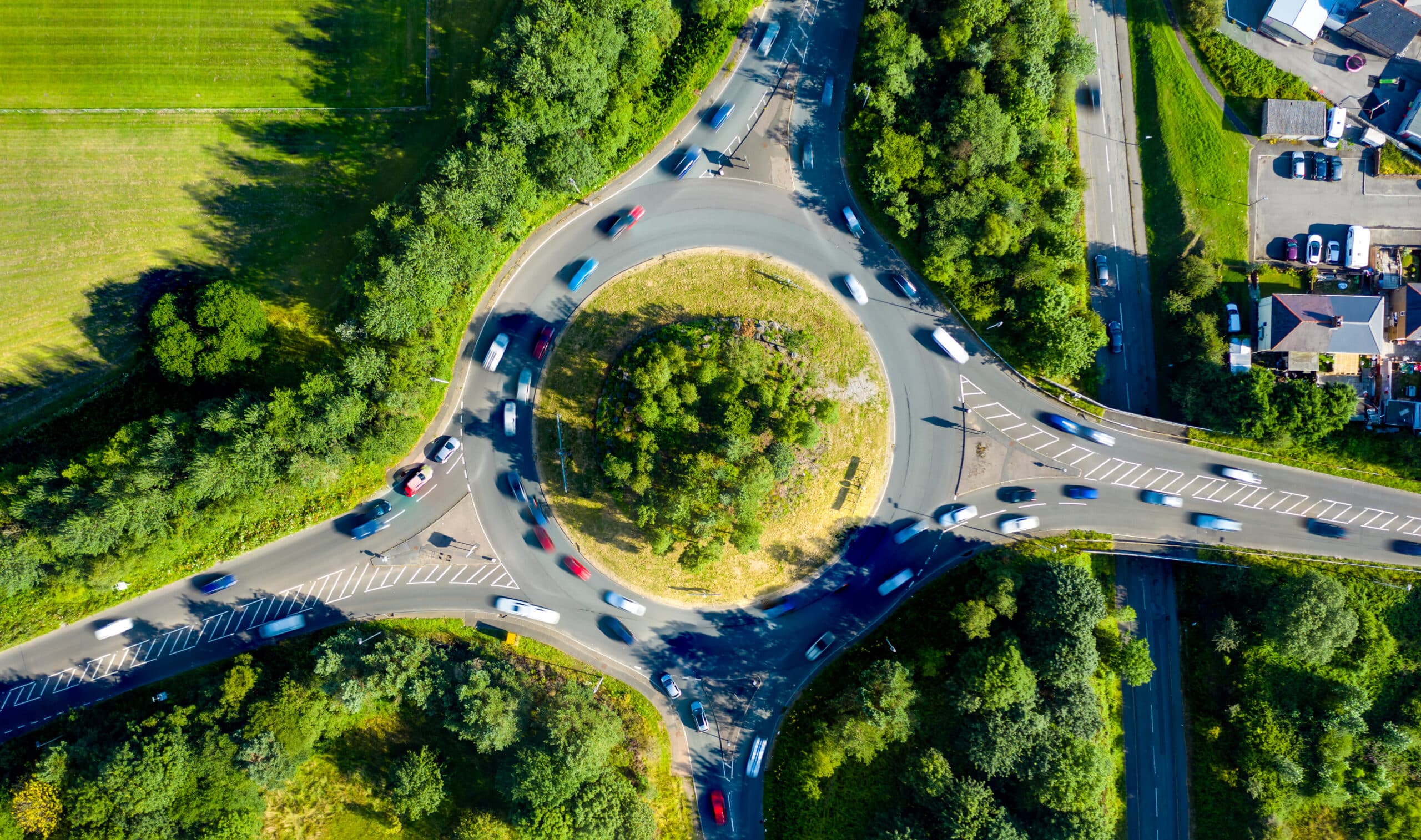 Composite aerial image of traffic using a small roundabout with